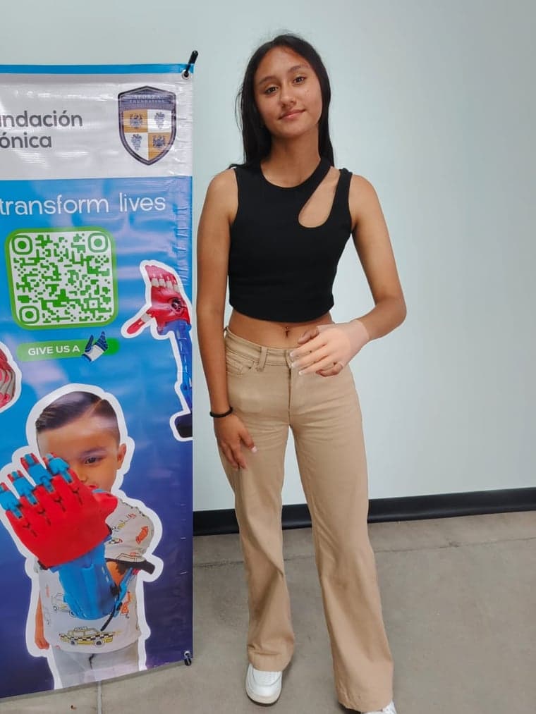 A young woman standing beside a Fundacion Bionica banner reading We transform lives.