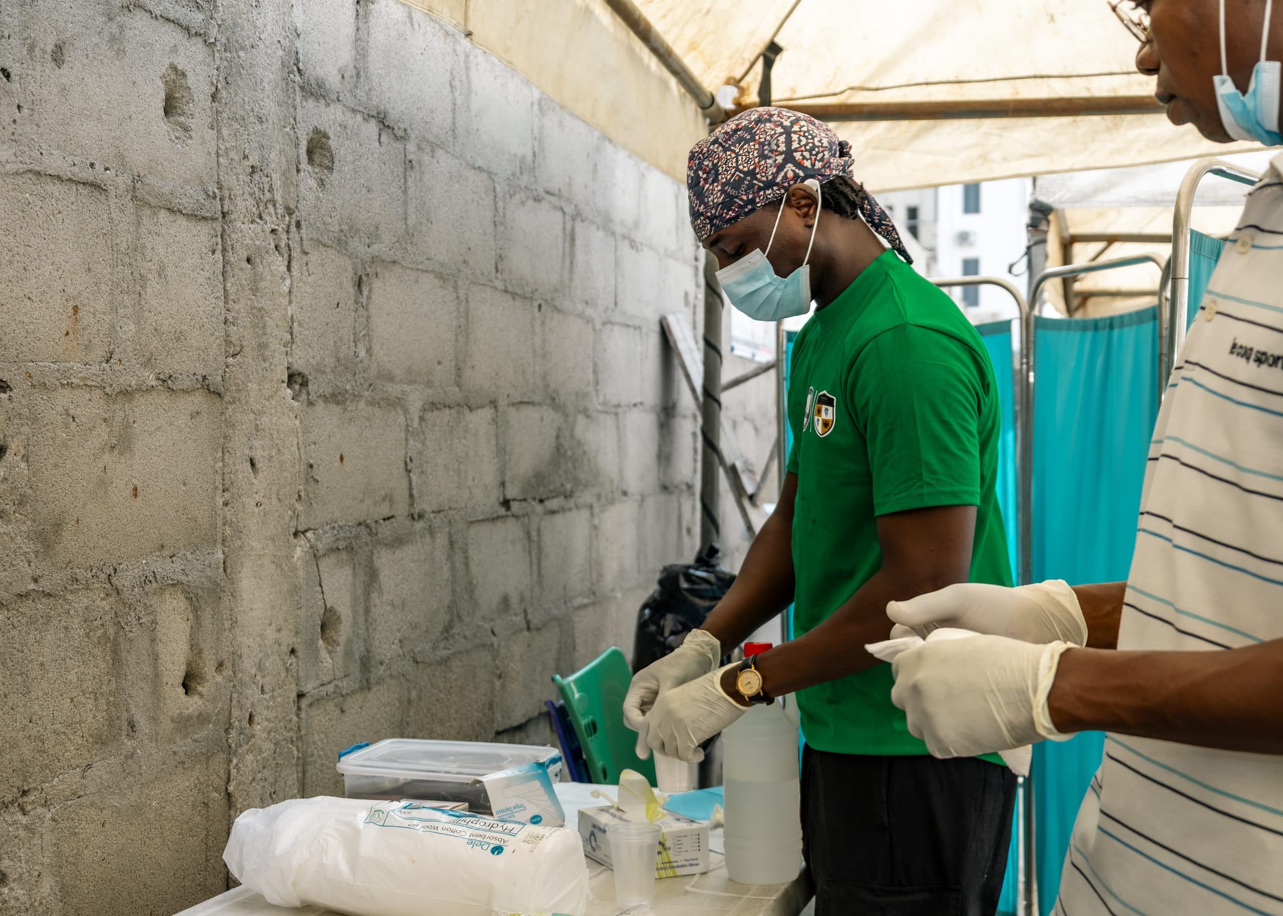A clinician in gloves running tests at a bench during the Ilasan medical outreach in Lekki, Lagos.