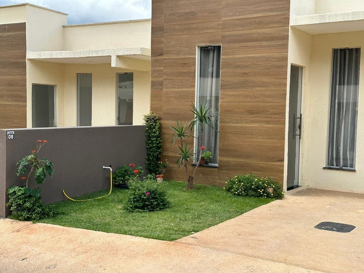 A finished single storey house with a planted front garden on a residential street in Brazil.