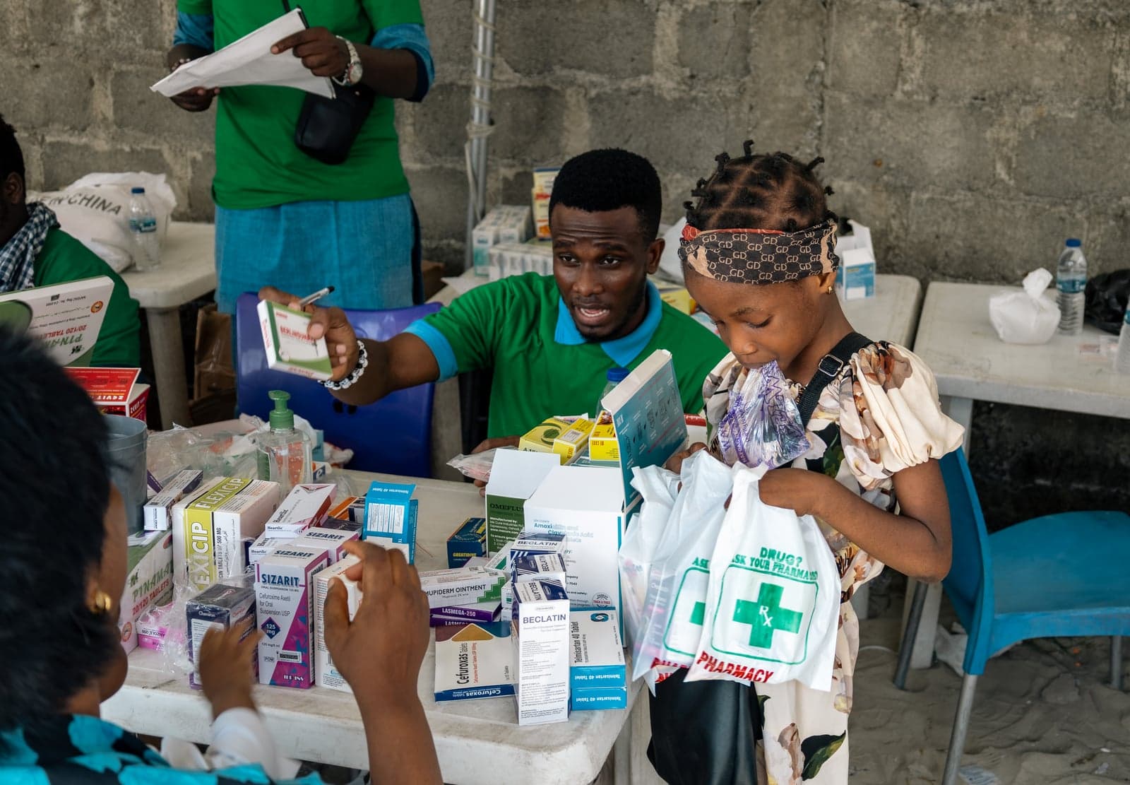 A girl receiving a bag of medicine at the pharmacy table at the Ilasan medical outreach in Lekki, Lagos.